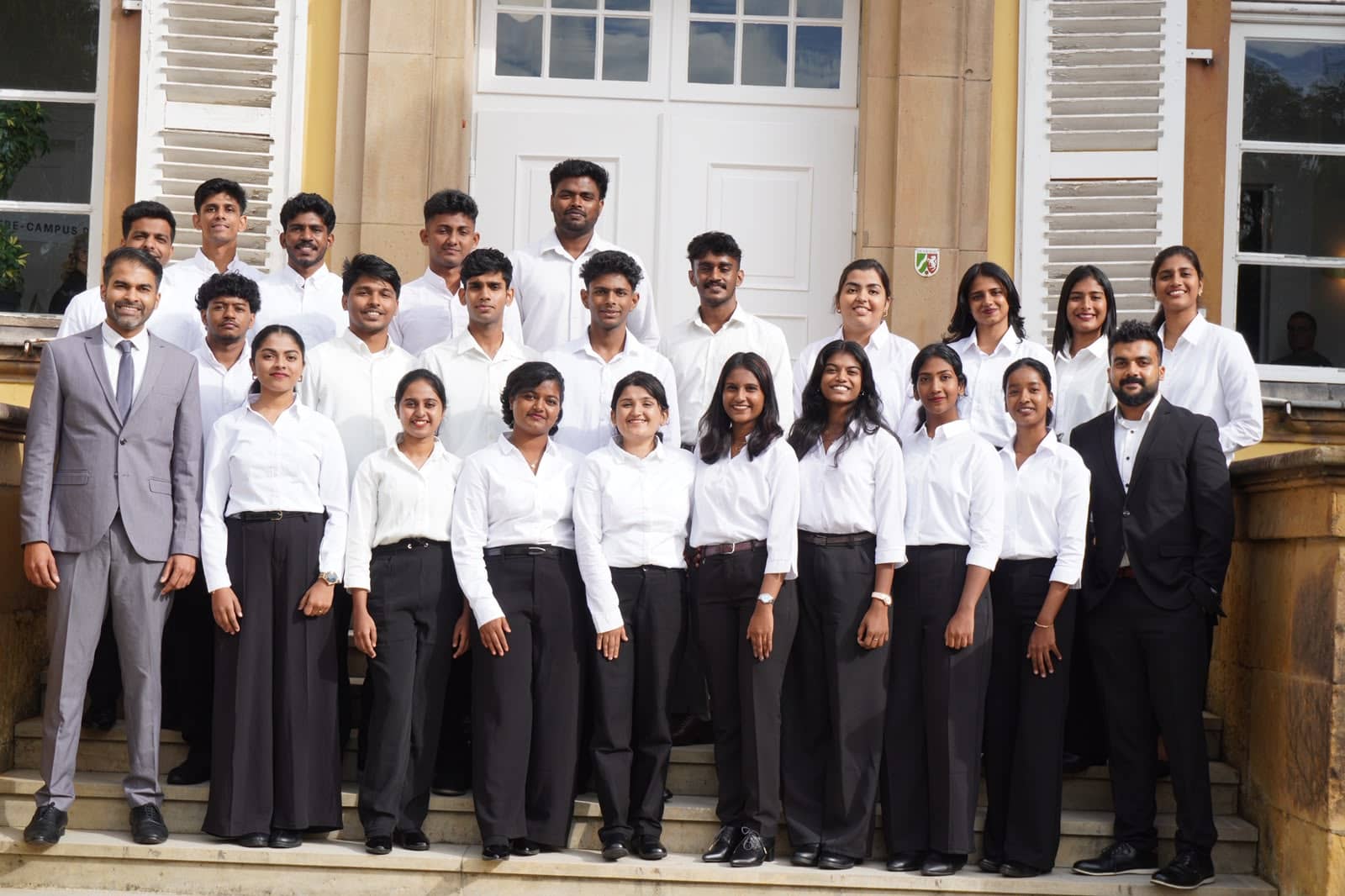 First-batch students in front of the castle campus entrance